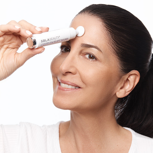 Model 5 applying Liquid Facelift to forehead